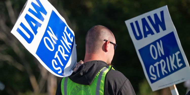 Striking autoworkers want to end a system that pays different wages for the same job